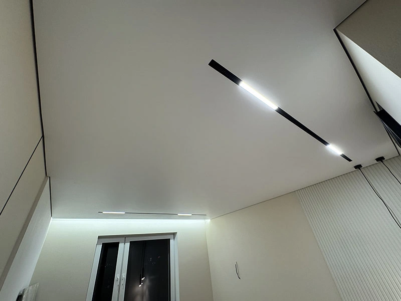 Яркий линейный LED-светильник во встроенном шинопроводе на натяжном потолке