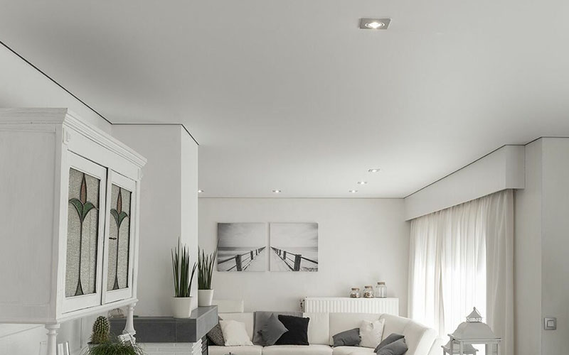 Иллюзия парящего натяжного потолка благодаря теневому профилю в интерьере светлой гостиной