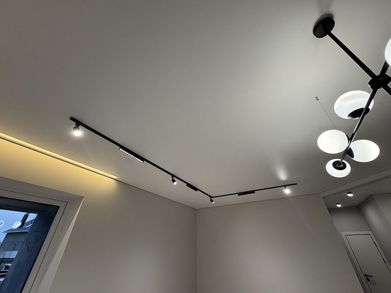 Проект: сочетание встроенного трека и современной люстры на белом натяжном потолке